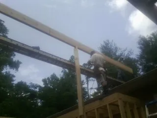 Carpenter setting a ridge beam over a new addition frame — Ice Dam Removal by Roofing Brothers in Elk River