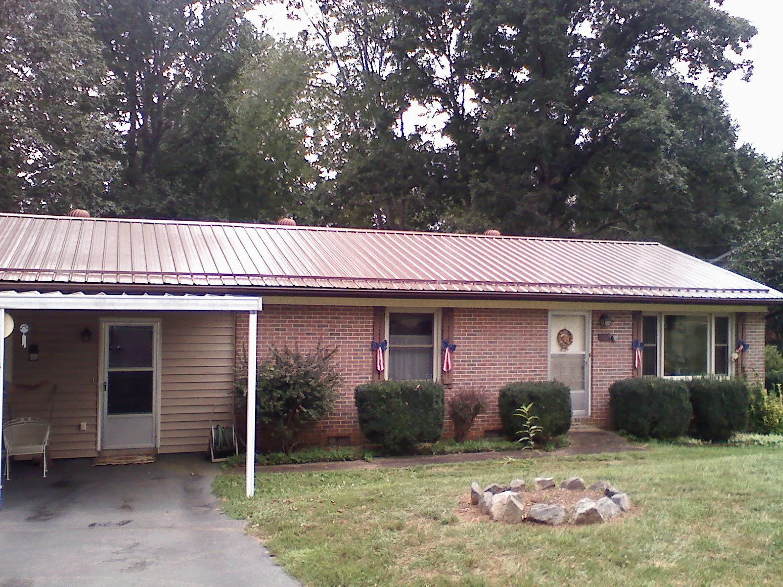 Bronze metal roof and carport on a brick ranch home — Roof Repair work by our crew in Elk River